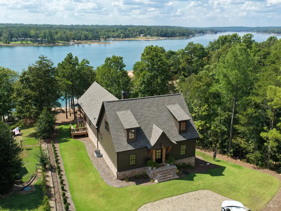 High aerial view of a Still Oak Homes lake house and the surrounding lake
